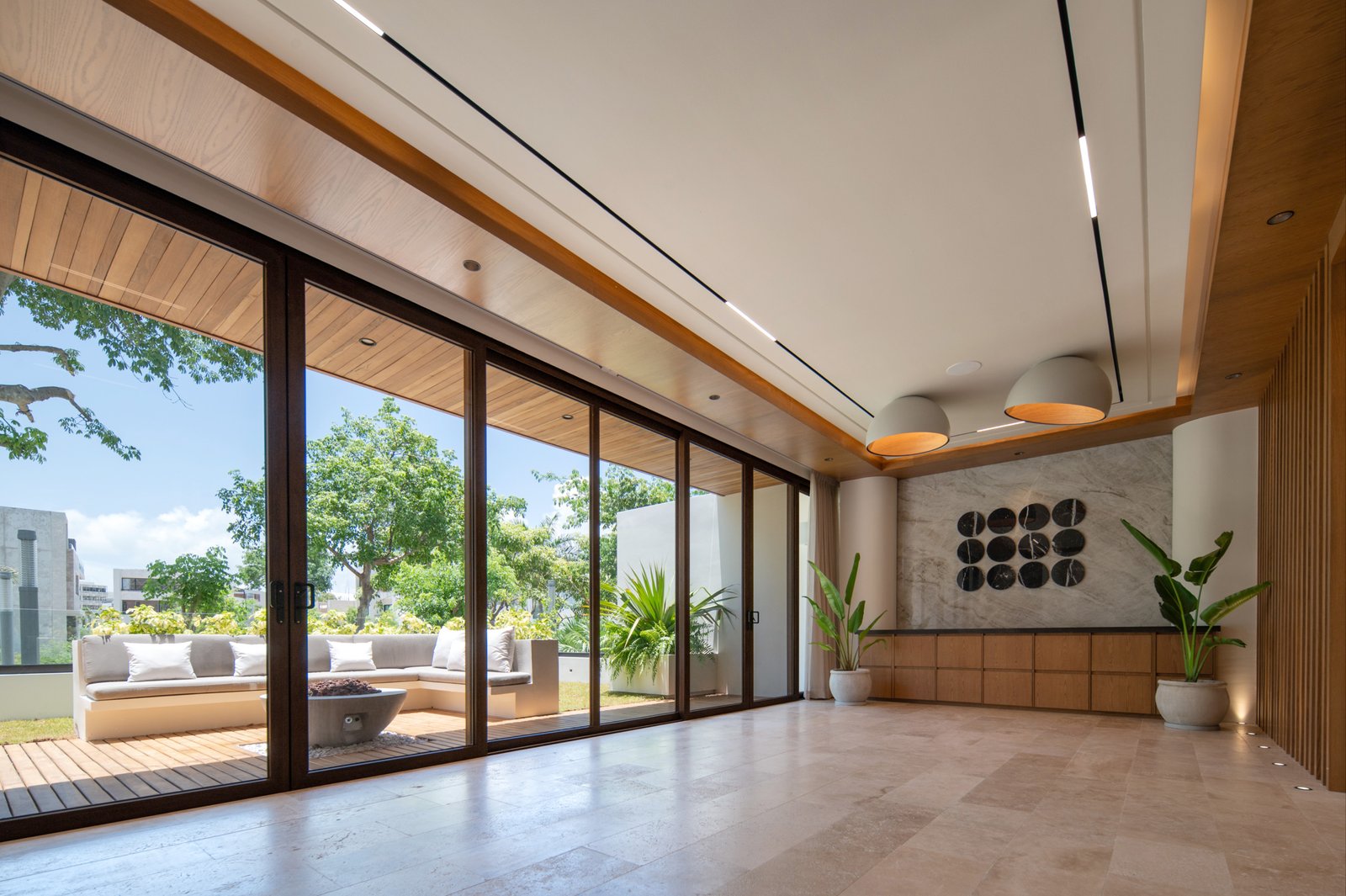 Casa en venta en puerto cancún-Espaciosa área interior con amplios ventanales corredizos que conectan con una terraza exterior