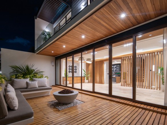 Casa en venta en puerto cancún - Terraza iluminada al anochecer con cómodos sofás, una moderna fogata y piso de madera