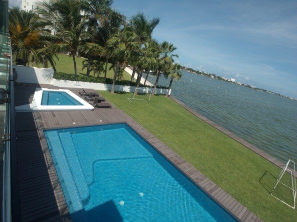 House for sale Isla Dorada Cancún – pool with lagoon view and hotels in the background
