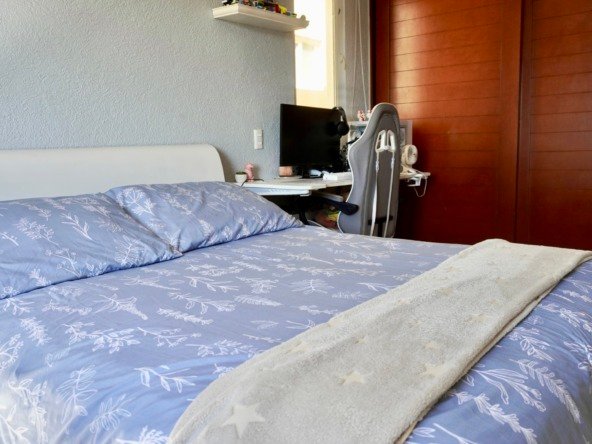 Departamento en venta en centro cancún - Recámara con cama vestida con tonos lavanda, al fondo un clóset de madera