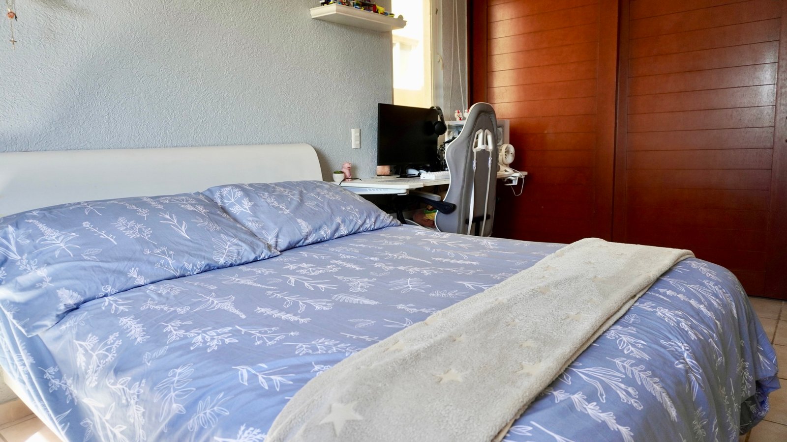 Departamento en venta en centro cancún - Recámara con cama vestida con tonos lavanda, al fondo un clóset de madera